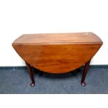 An early 20th century mahogany drop leaf table on pad feet,