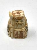 A Japanese carved bone netsuke - Village elder holding a staff.