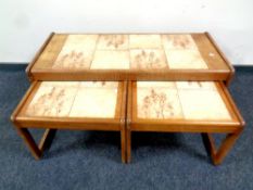 A 20th century nest of teak and tile topped tables,