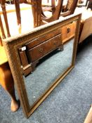 A large gilt framed bevelled overmantel mirror