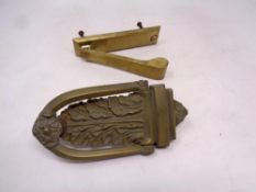 An antique brass door knocker together with one further door knocker