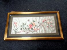 A Japanese silk embroidered panel in a gilt frame depicting a bird of paradise,