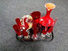 A tray of ruby red coloured glass, decorative figures,