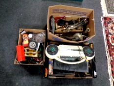 Three boxes containing brass candlesticks, decorative ornaments, die cast vehicles,