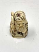 A Japanese carved bone netsuke - Village elder holding a scroll.