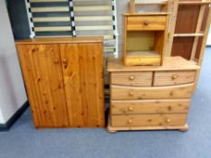 A pine double door cabinet together with a pine traditional five drawer chest and a bedside cabinet,