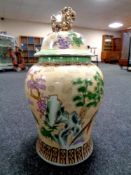 A large decorative Chinese lidded urn decorated with birds in a landscape