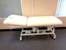 A white vinyl electric adjustable treatment couch