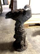 A concrete garden figure of an eagle on plinth