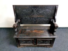 A late 19th century carved oak bench,