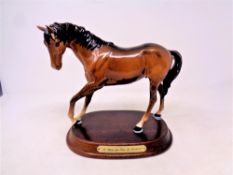 A Beswick figure modelled as a horse with foot raised,