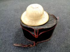 An early 20th century hat box containing a pith hat