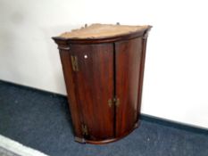 A George III bow fronted corner cabinet,