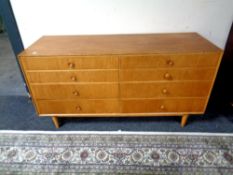A mid century oak effect eight drawer low chest, width 131 cm, height 66.