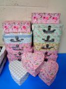A quantity of floral patterned graduated storage boxes and cases