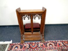 A late 19th century oak church kneeler with gothic style carvings,