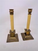 A pair of brass telescopic column candlesticks