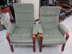 A pair of stained beech framed Scandinavian armchairs upholstered in a green button dralon