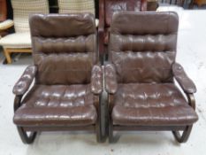 A pair of 20th century Scandinavian stained beech framed armchairs upholstered in brown leather