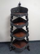 A 19th century heavily carved hardwood Burmese four tier corner whatnot stand