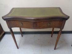A Regency style mahogany serpentine fronted turnover top tea table with a green leather inset panel