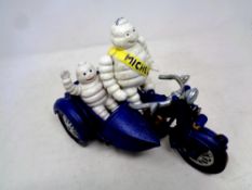 A cast iron Michelin Man on motorbike with sidecar