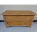 An antique pine two drawer chest