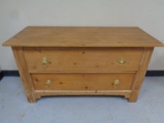 An antique pine two drawer chest