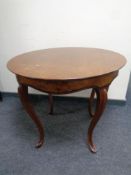 A mahogany and walnut circular occasional table on cabriole legs