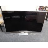 A Samsung SU HD 65'' curved TV with lead and remote