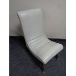 A mid 20th century nursing chair upholstered in a cream vinyl