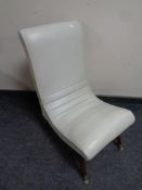 A mid 20th century nursing chair upholstered in a cream vinyl