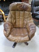 A 20th century Scandinavian swivel armchair upholstered in brown leather