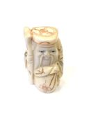 A Japanese carved bone netsuke - Village elder with a sack at his feet.