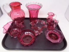 A tray containing eight pieces of antique cranberry glassware