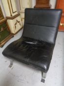 A Scandinavian black leather low lounge chair on chrome metal legs