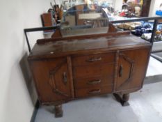A 1930s oak double door mirror back sideboard fitted four central drawers