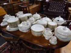 An extensive antique white and gilt dinner service to include multiple tureens with spoons,