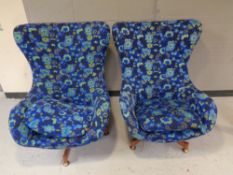 A pair of mid 20th century swivel egg chairs upholstered in a blue floral fabric