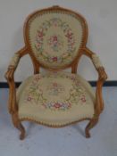 A carved beech French salon armchair upholstered in a tapestry fabric