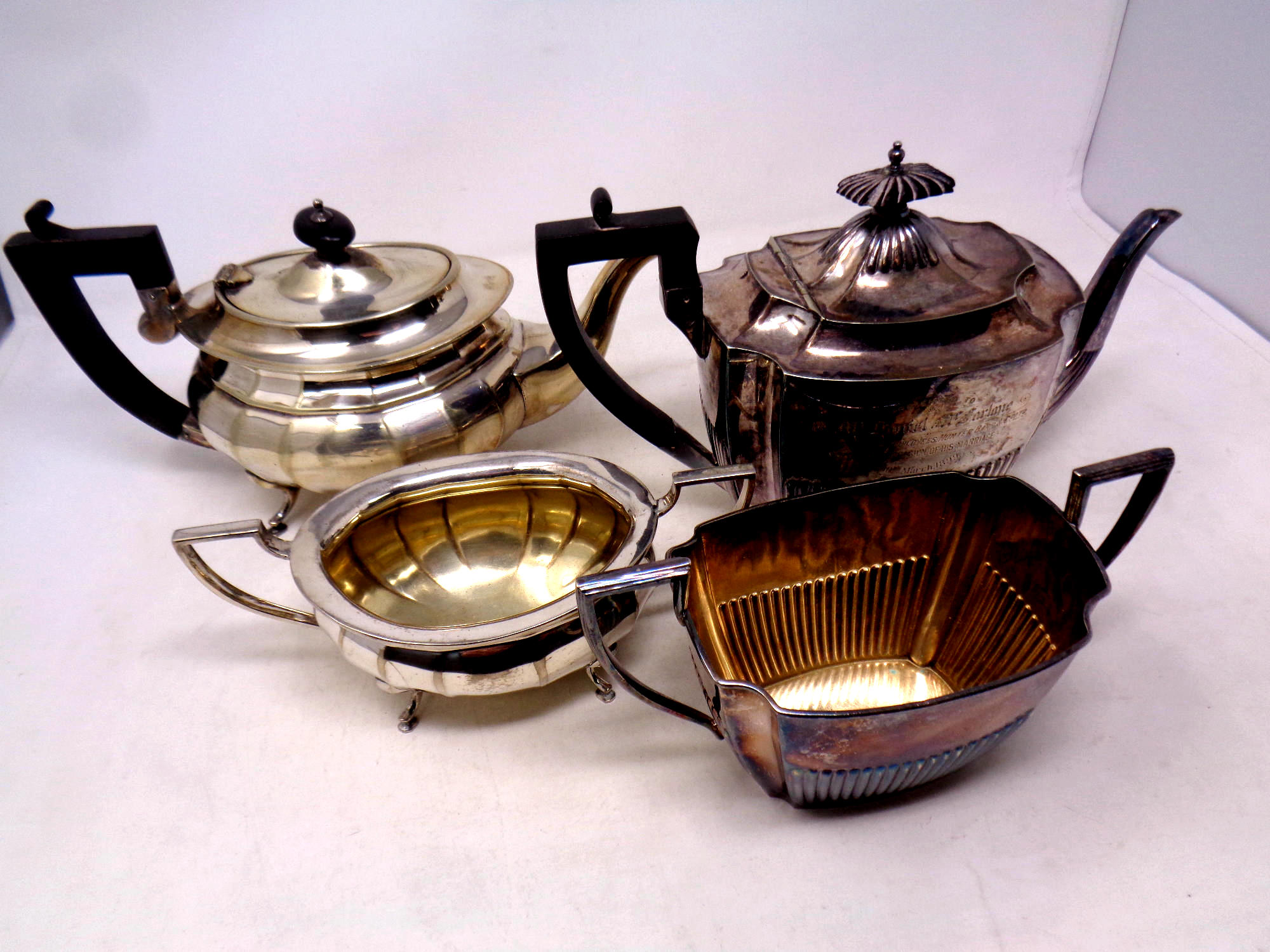 Two antique silver plated teapots with sugar basins