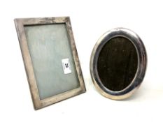 Two silver photograph frames, oval 17.5 cm x 13.5 cm and rectangular 14 cm x 20.5 cm.