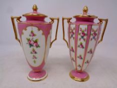 A pair of Minton twin handled lidded urns decorated with pink roses,