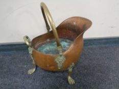 A 19th century copper and brass coal bucket on paw feet
