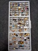 A printer's type tray containing a large quantity of costume jewellery