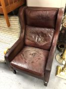 A 20th century wingback armchair upholstered in brown leather