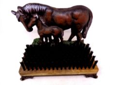 A cast iron horse door stop with boot brush