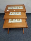 A nest of three mid 20th century teak tile topped tables