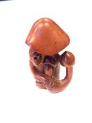 A Japanese carved fuitwood netsuke - A monkey under a toadstool.