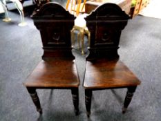A pair of late 19th century carved oak hall chairs